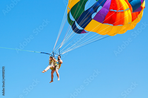 people parakiting on parachute in blue sky