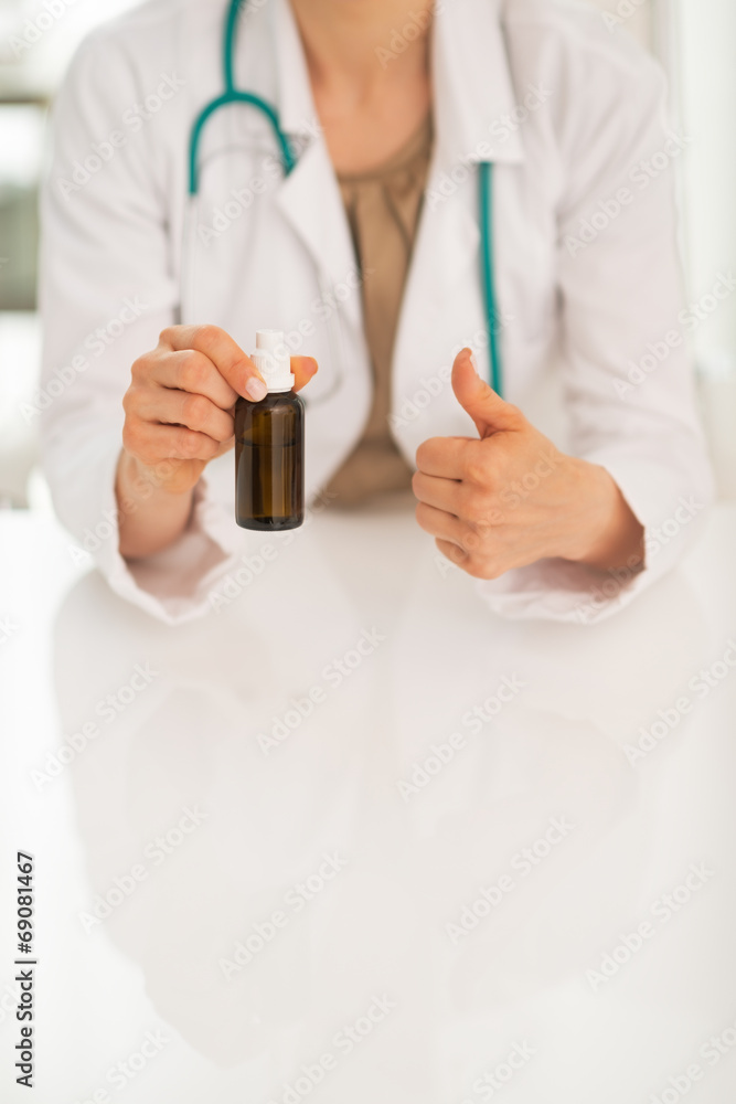 Closeup on doctor woman showing medicine bottle and thumbs up Closeup on doctor woman showing medicine bottle and thumbs up