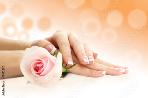 Young woman hands with elegance manicure on bright background