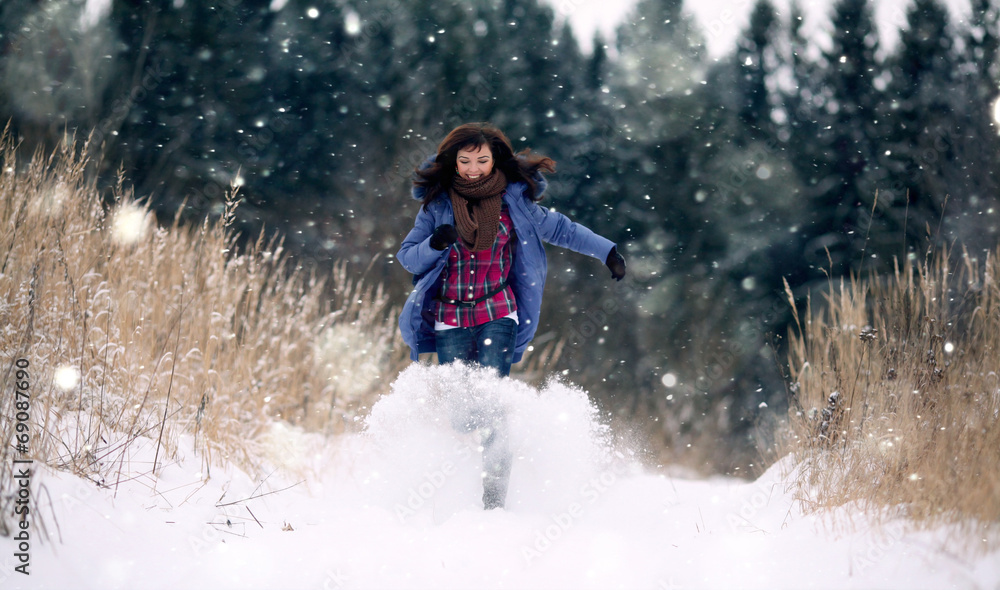 brunette girl running in a snowy forest brunette girl running in a snowy forest