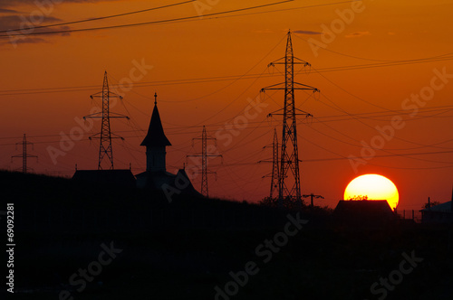 sunset, a church tower and electrical poles