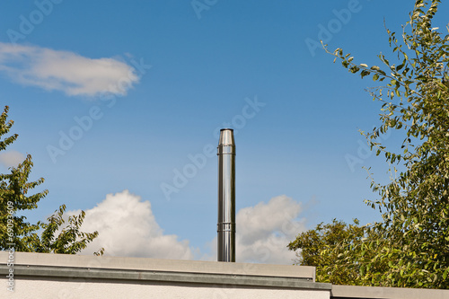 Ein Schornstein aus Edelstahl auf einem Flachdach