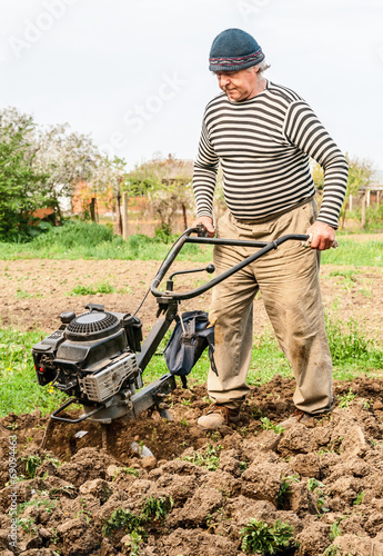 Farmer plowing the field. Cultivating tractor in the field