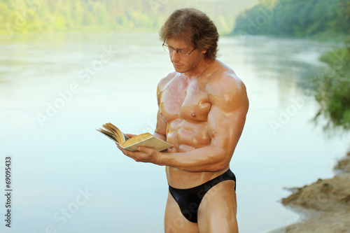 athletic man with enthusiasm reads the book 