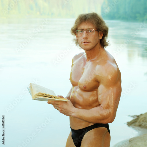 athletic man with enthusiasm reads the book 