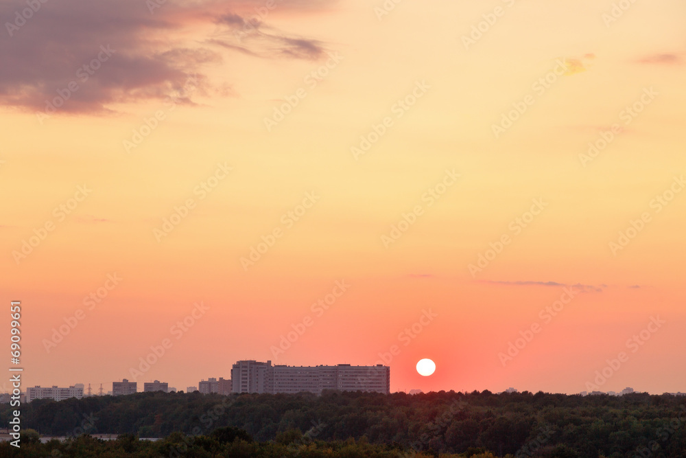 sun above horizon during red sunrise over city