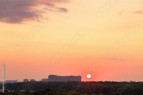 sun above horizon during red sunrise over city