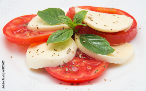 Caprese salad with mozarella cheese, tomatoes and basil