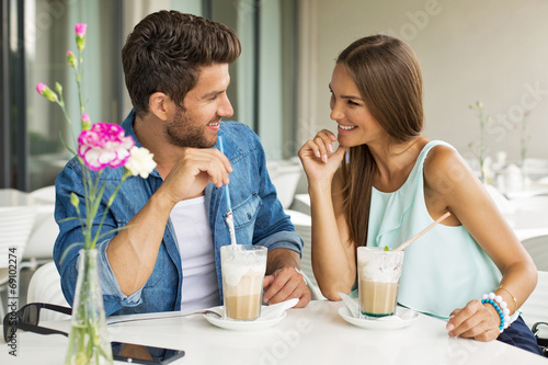Smiling couple in cafe enjoying the time spending with each othe
