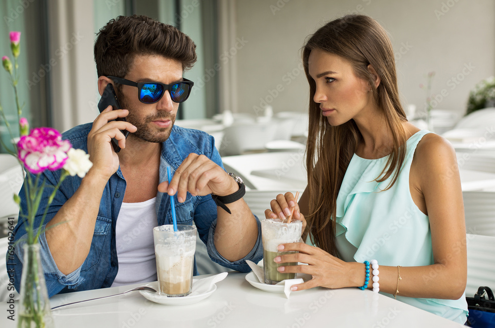 Handsome man with beautiful woman in cafe talking by the smartph Handsome man with beautiful woman in cafe talking by the smartph