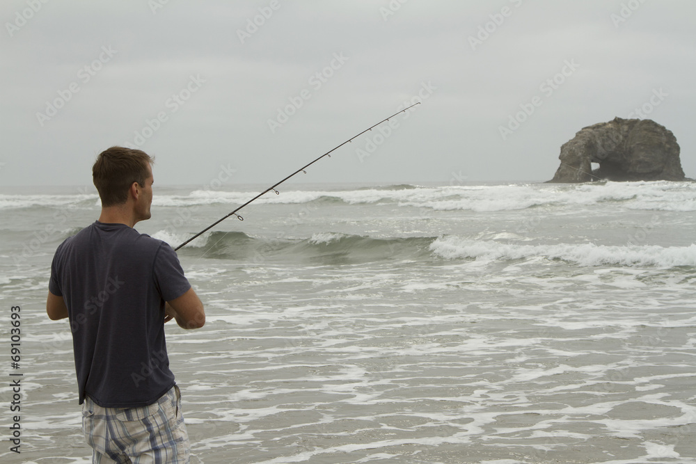 Man fishing in the surf on Rockaway beach Man fishing in the surf on Rockaway beach