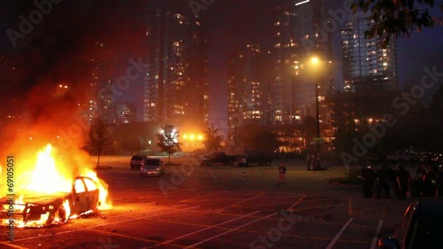 Car involved in flames with highrises and SWAT officers photo