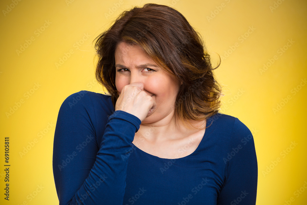 Woman pinches her nose, bad smell, yellow background Woman pinches her nose, bad smell, yellow background
