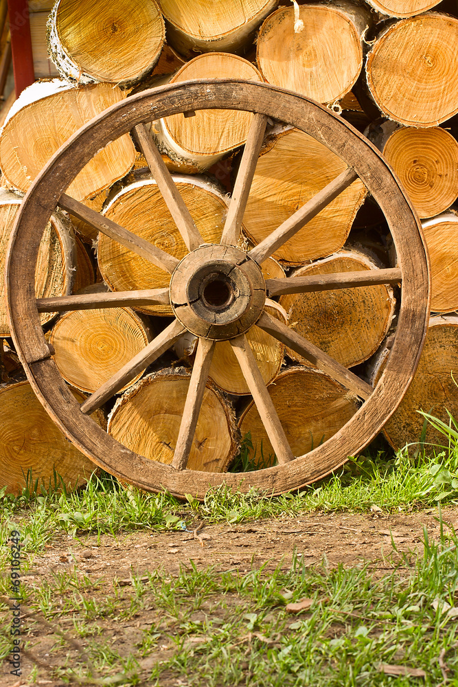 Old wagon wheel on a background of wood