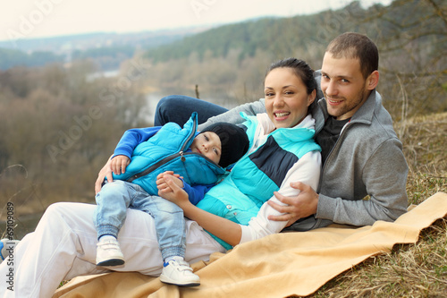 Young beautiful family picnicking on the hills. © ruslimonchyk