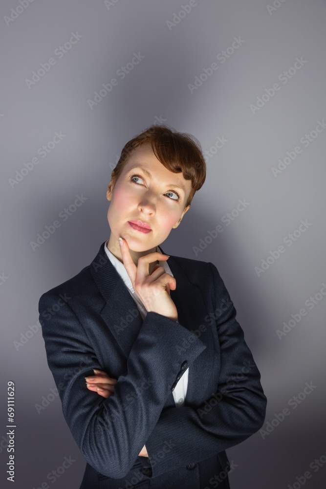 Businesswoman in suit thinking with finger on chin Businesswoman in suit thinking with finger on chin