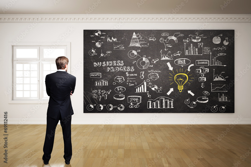 Geschäftsmann vor umfangreichem Business-Plan Geschäftsmann vor umfangreichem Business-Plan