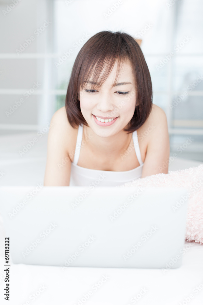 ベッドでパソコンを使う女性 ベッドでパソコンを使う女性
