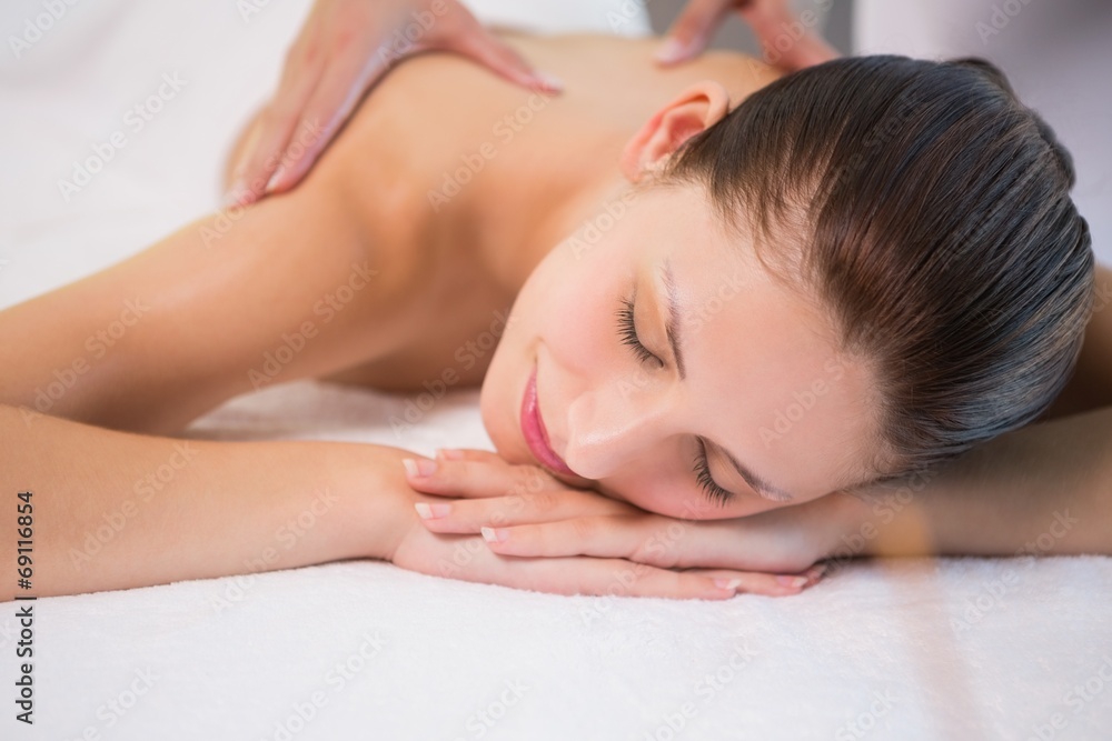 Attractive woman receiving back massage at spa center Attractive woman receiving back massage at spa center