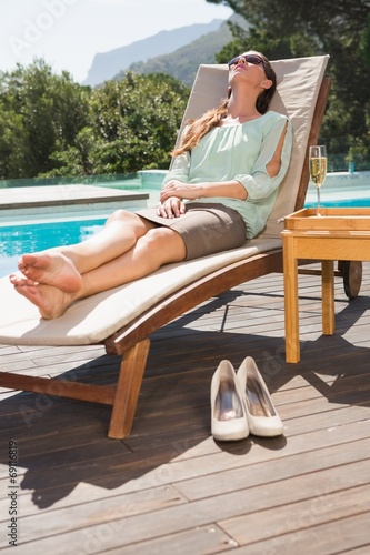 Beautiful woman relaxing on sun lounger by swimming pool © WavebreakmediaMicro
