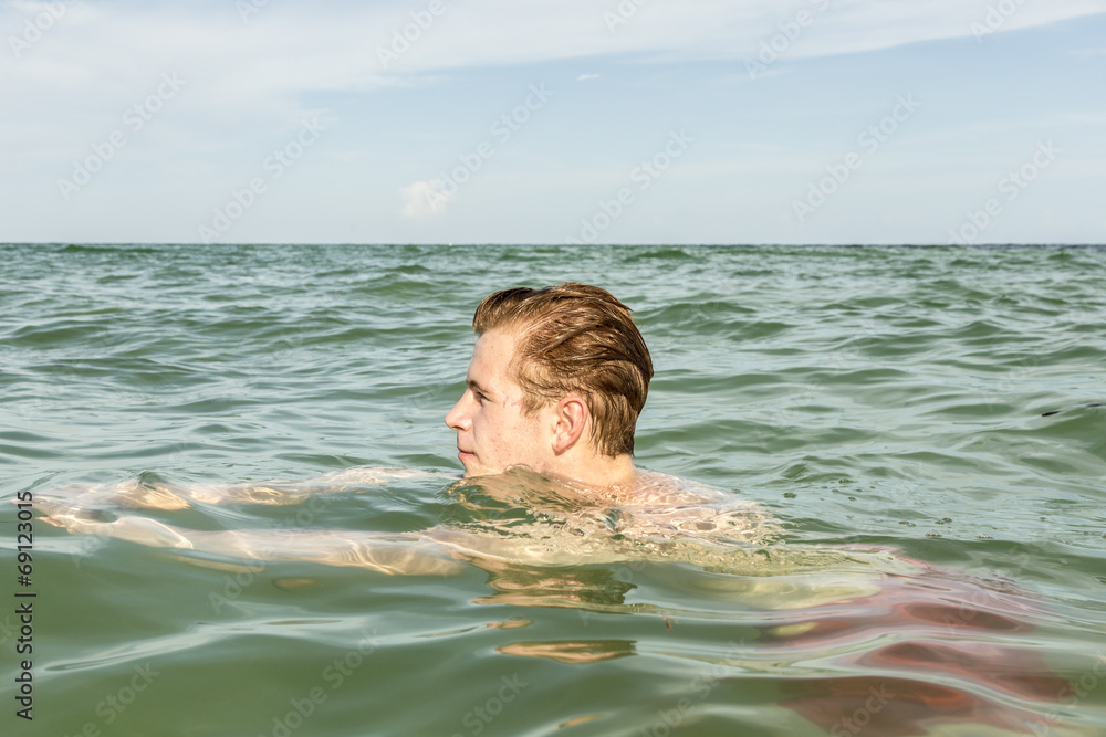 teenage boy enjoys swimming in the ocean