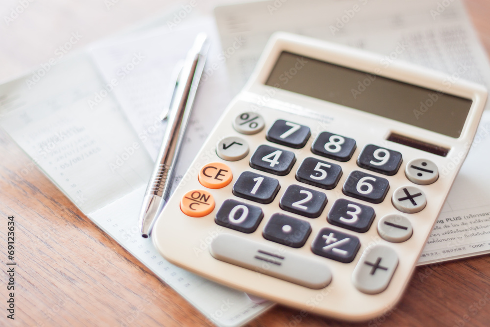 Calculator and pen on bank account passbook Calculator and pen on bank account passbook