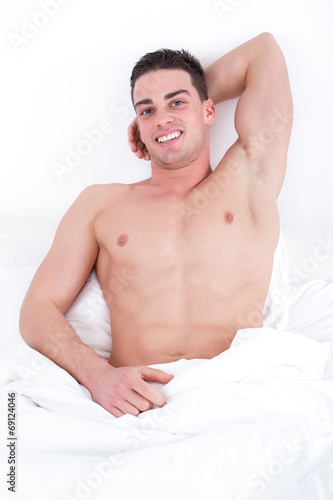 sexy man lying on the bed smiling