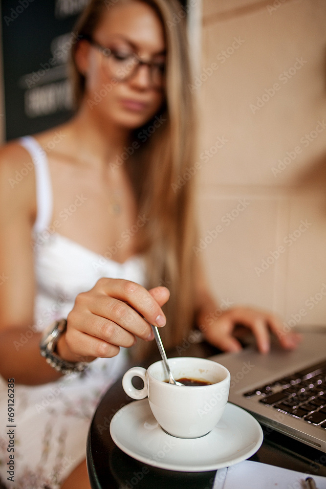 Young business woman in cafe drinking coffee with laptop Young business woman in cafe drinking coffee with laptop