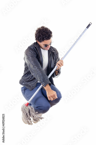  man in leather jacket jumps with a broom