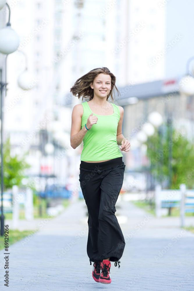 Woman jogging in city street park.
