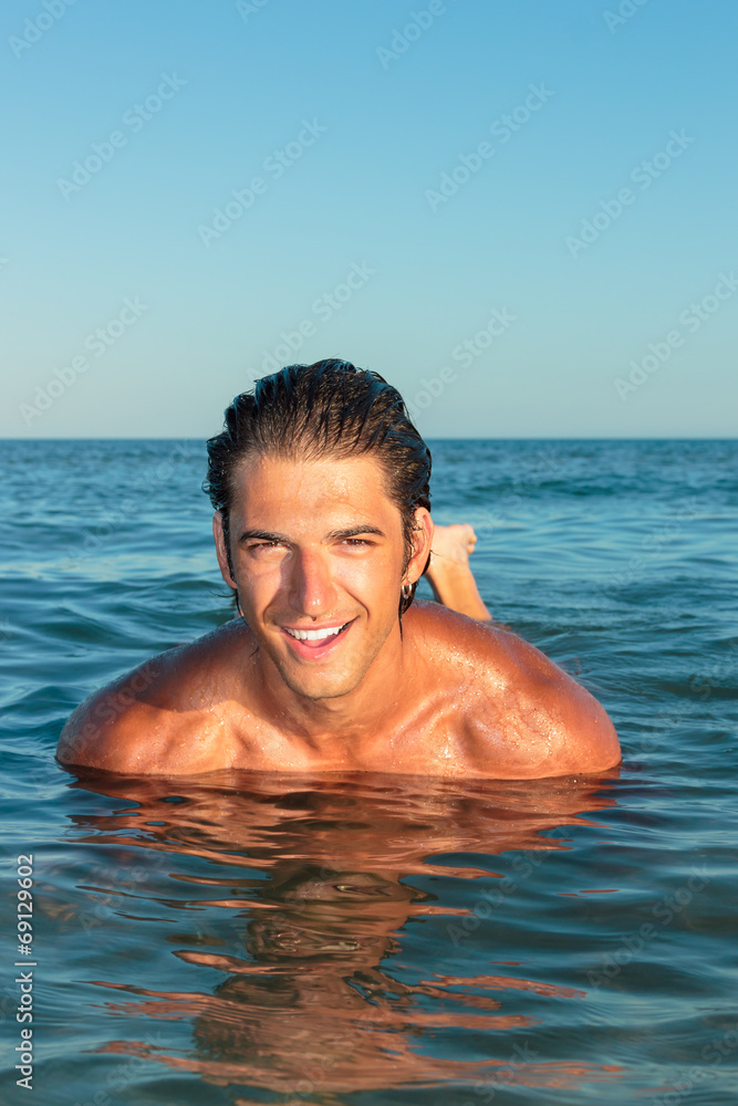 Portrait of a handsome young muscular man in swimwear