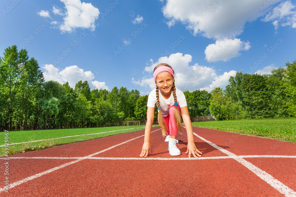 Girl in ready position on bend knee to run Girl in ready position on bend knee to run