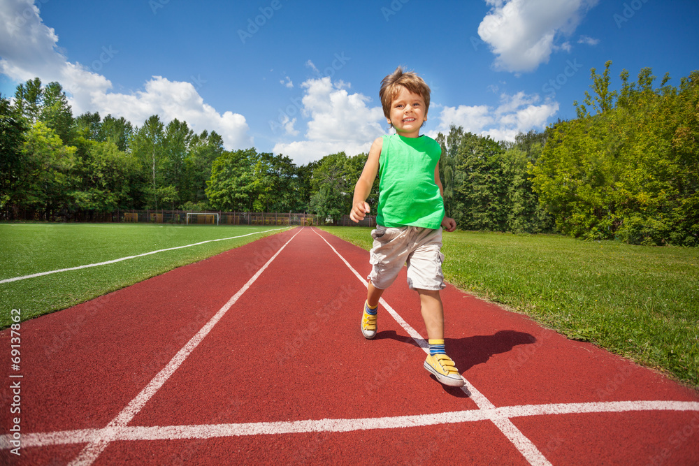 Cute small boy runs slowly on the marathon road