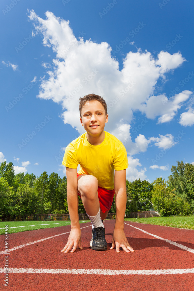 Smiling boy in ready position to run marathon