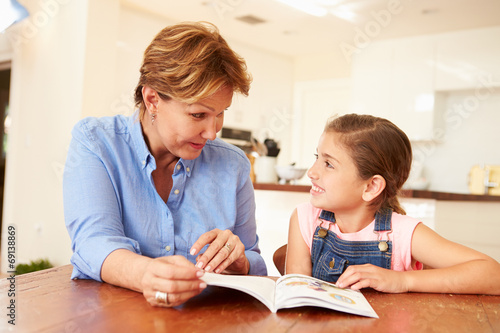 Grandmother Reading With Granddaughter At Home © Monkey Business