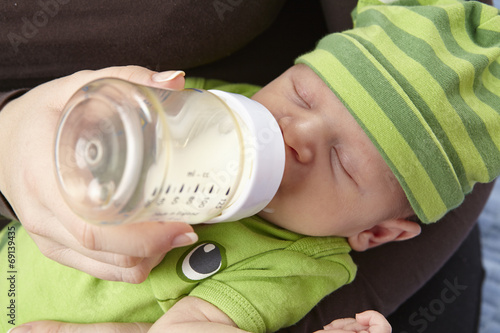 Säugling (Baby) bekommt das Fläschchen photo