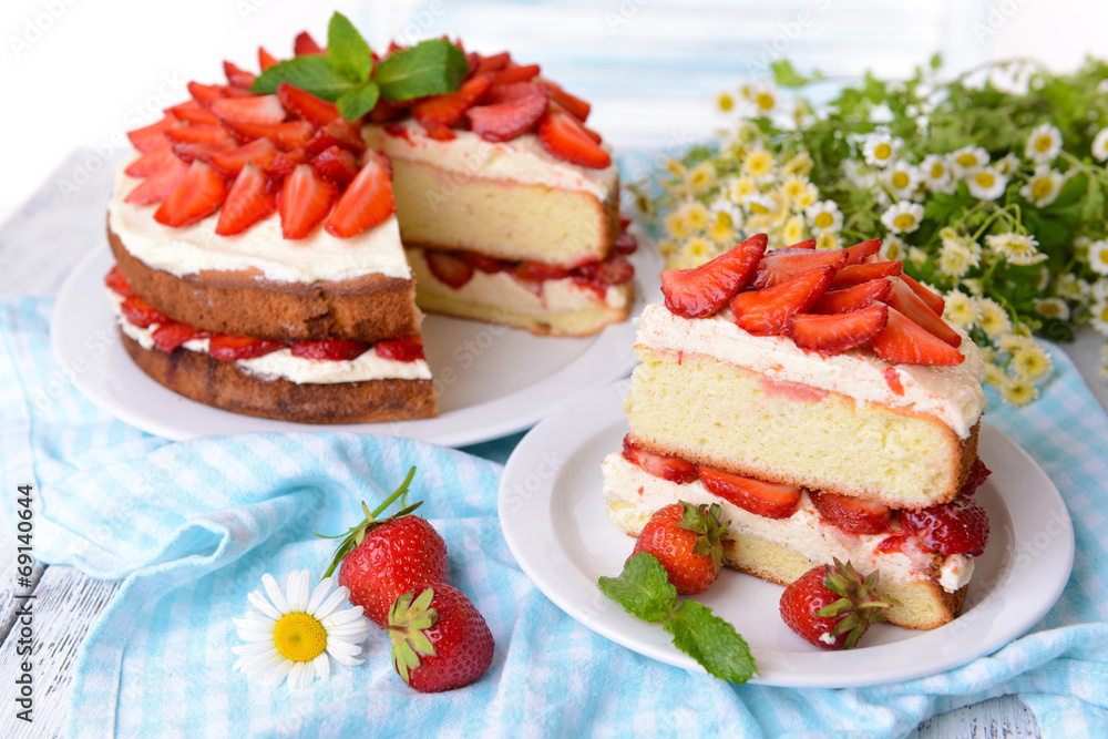 Delicious biscuit cake with strawberries on table close-up