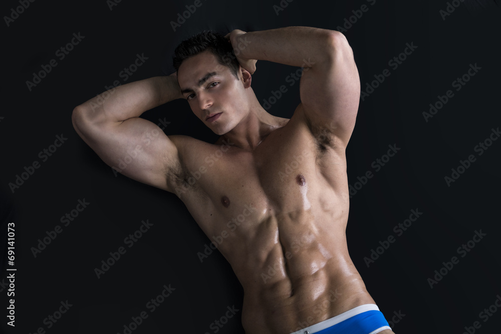 Young man laying on the floor with naked muscular body Young man laying on the floor with naked muscular body
