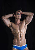 Attractive young man standing with muscular ripped body