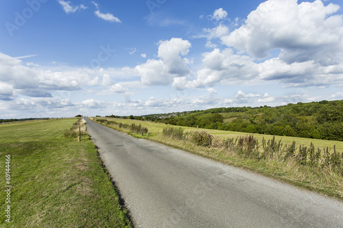 Country lane on a sunny and cloudy summer s day