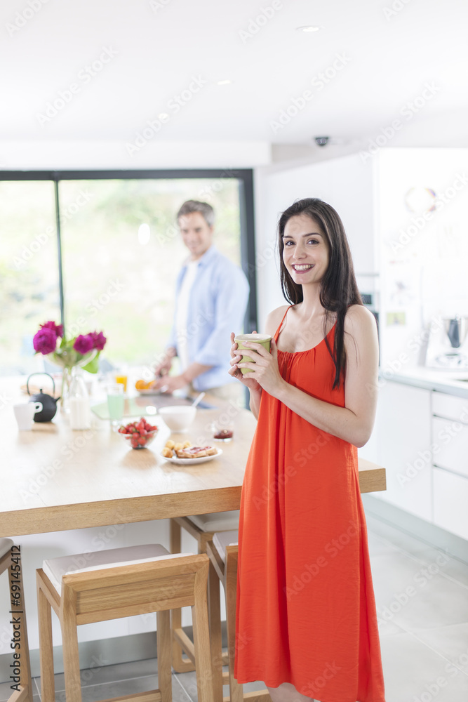 couple in the kitchen in the morning woman at foreground couple in the kitchen in the morning woman at foreground
