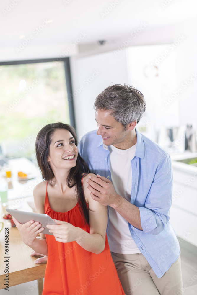 Fototapeta premium cheerful couple at home using digital tablet