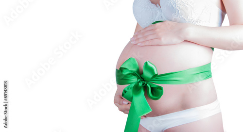 Obraz na płótnie Beautiful young pregnant woman with green ribbon. Isolated on wh w salonie