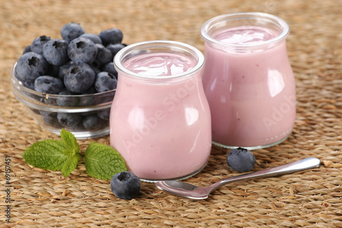 yogurt with blueberries in a glass jar and blueberries in a glas