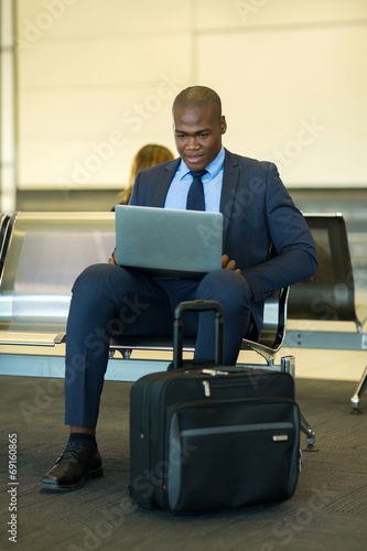 african businessman using tablet computer at airport