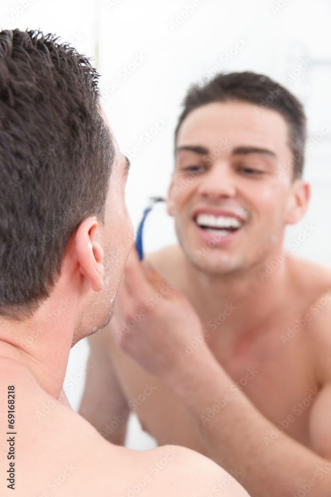 smiling man shaving in bathroom getting ready for the day smiling man shaving in bathroom getting ready for the day