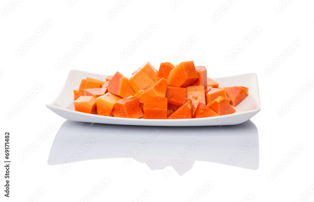 Bite sized papaya fruit on white plate over white background Bite sized papaya fruit on white plate over white background