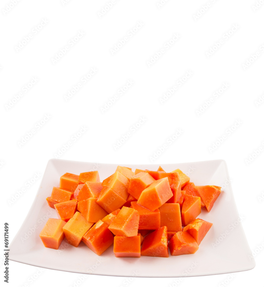 Bite sized papaya fruit on white plate over white background Bite sized papaya fruit on white plate over white background