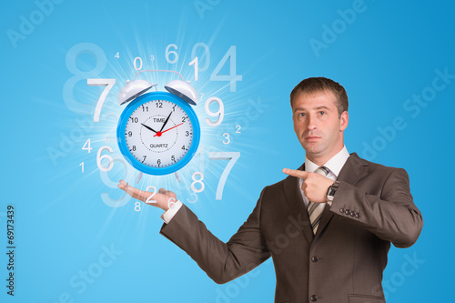 Businessman hold alarm clock with figures