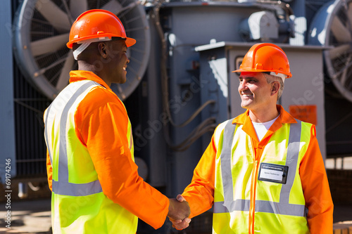 power company co-workers hand shaking